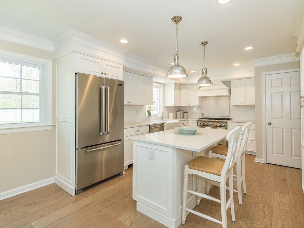 White kitchen remodel with shaker cabinets, quartz countertops, subway tile backsplash and hardwood flooring in Morris County, NJ renovated by JMC Home Improvement Specialists