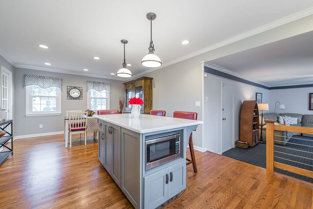 White and Grey two tone eat in kitchen remodel with hardwood flooring, quartz counters, pendant lighting over island, microwave shelf in island, LED highhats in Parsippany, NJ remodeled by JMC Home Improvement Specialists