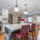 Eat in two tone open concept kitchen remodel with herringbone white backsplash, freestanding hood, white shaker cabinets, quartz counters, pendant lighting over island and LED highhats, grey and white cabinets with red accents in Parsippany, NJ remodeled by JMC Home Improvement Specialists