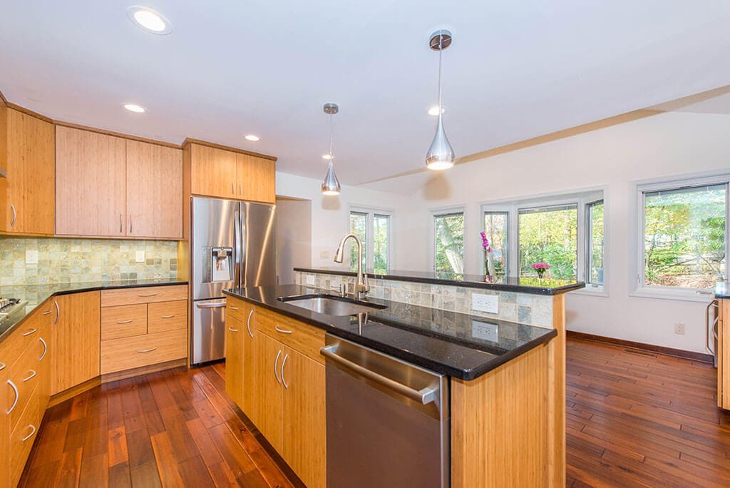 Modern bamboo eat-in kitchen remodel with slab doors, granite counters, pendant lights and undermount sink in Randolph, NJ renovated by JMC Home Improvement Specialists