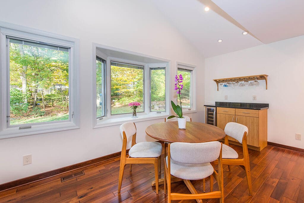 Modern bamboo eat-in kitchen remodel with slab doors, vaulted ceiling, bay window and wine fridge at bar area in Randolph, NJ renovated by JMC Home Improvement Specialists