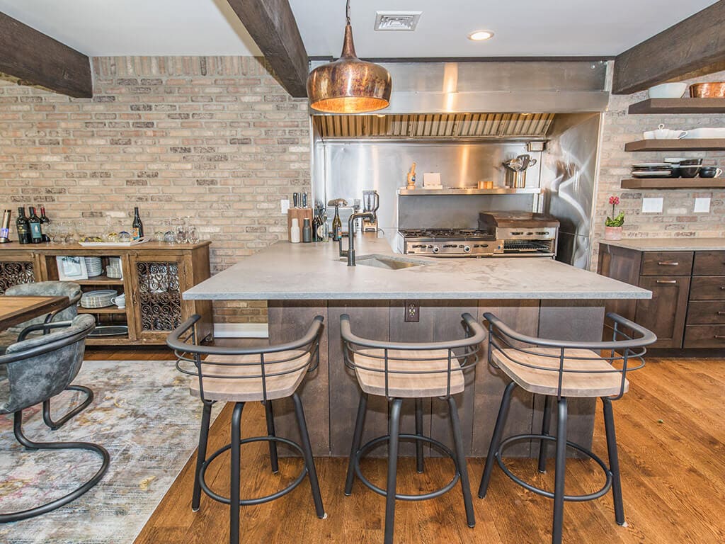 Open concept industrial kitchen with exposed brick wall concrete countertop in Rockaway, NJ remodeled by JMC Home Improvement Specialists