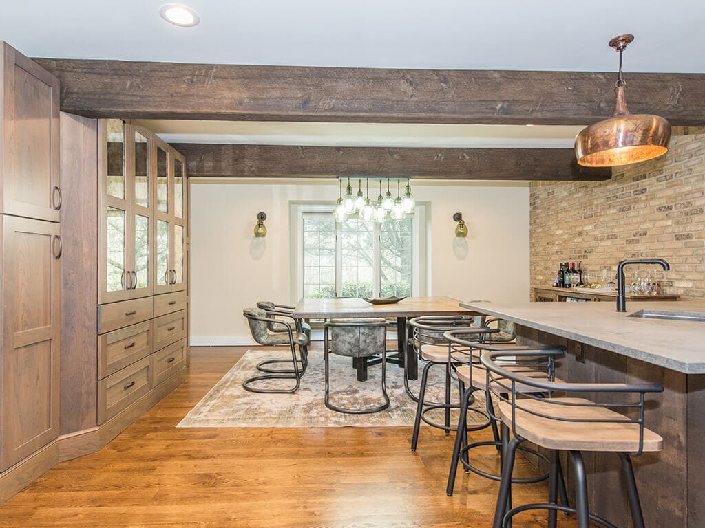 Open floor plan industrial kitchen with exposed brick, wood beams, concrete countertop with and hardwood floor in Rockaway, NJ remodeled by JMC Home Improvement Specialists