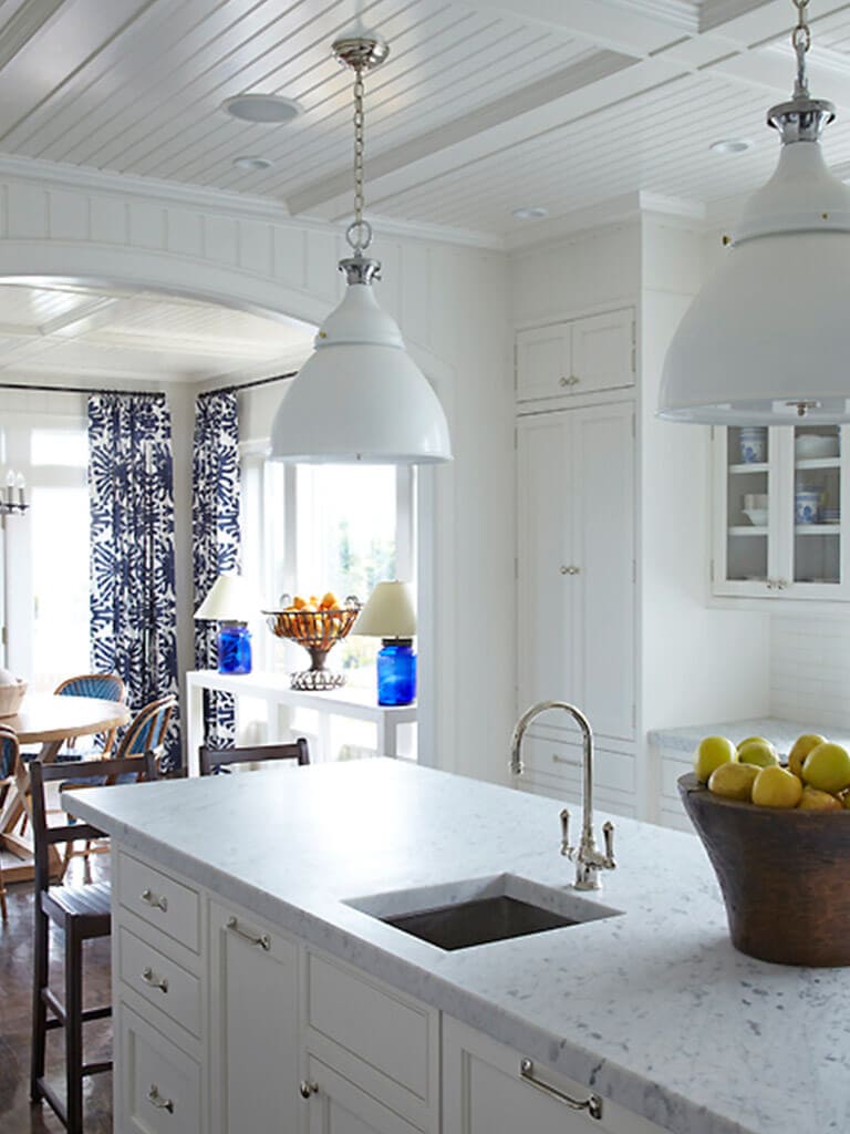 White kitchen with beadboard, white shaker double stack cabinets with glass doors, arch opening, Carrera marble counters in Springlake, NJ remodeled by JMC Home Improvement Specialists