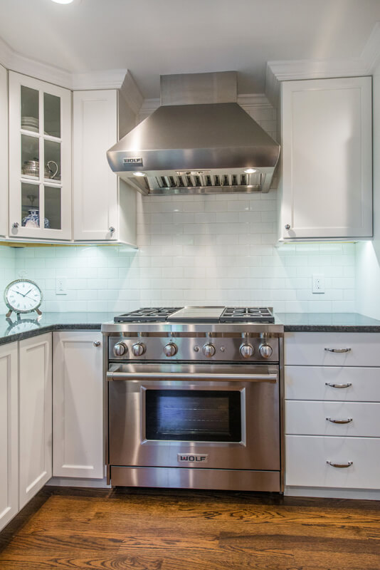 White kitchen with shaker cabinets, subway tile backsplash, metal freestanding hood black with pearl granite countertops in Morris County, NJ remodeled by JMC Home Improvement Specialists