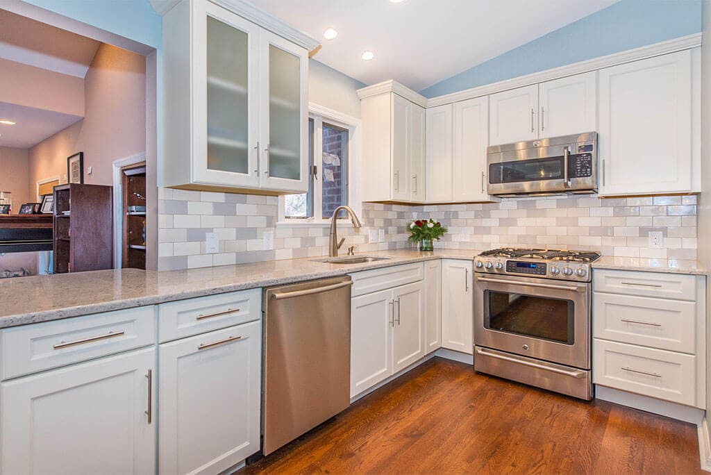 White Shaker cabinets with subway tile backsplash and hardwood floors in Summit, NJ remodeled by JMC Home Improvement Specialists