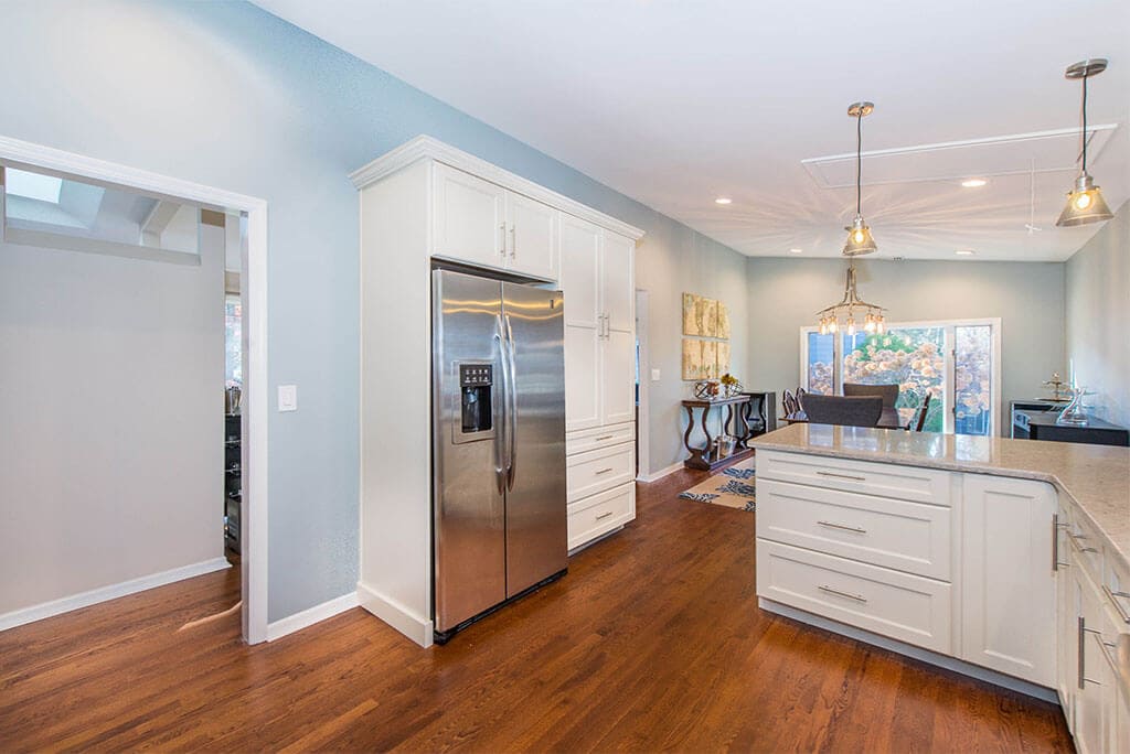 Open floor concept kitchen with white Shaker cabinets with subway tile backsplash and hardwood floors in Summit, NJ remodeled by JMC Home Improvement Specialists