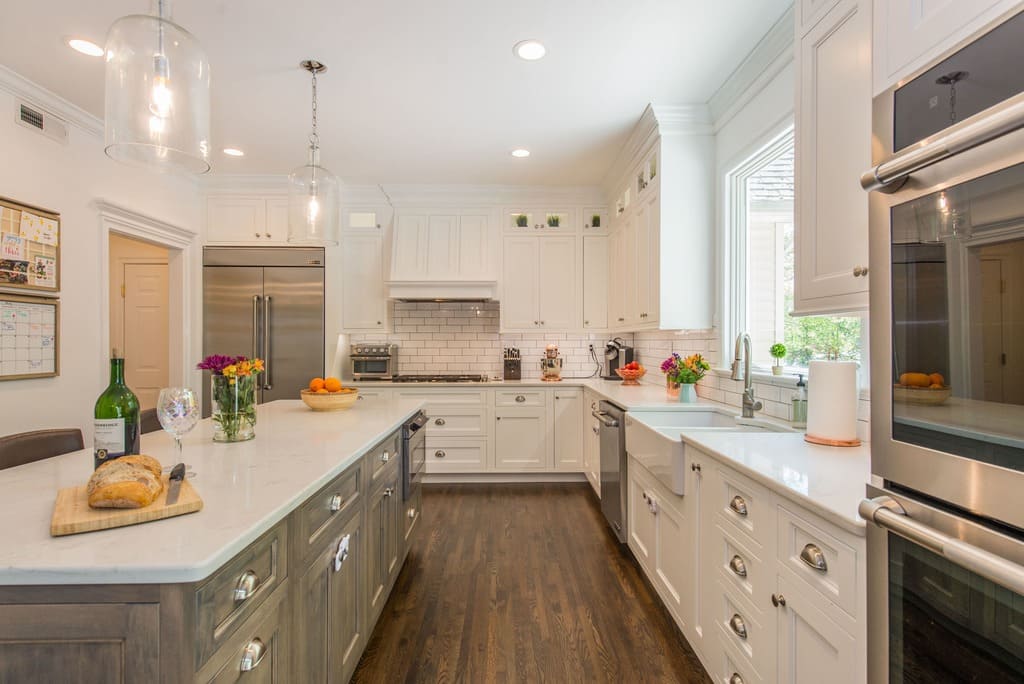 White shaker kitchen cabinets with cup pulls and glass cabinets and custom wood hood over stove in Randolph, NJ remodeled by JMC Home Improvement Specialists