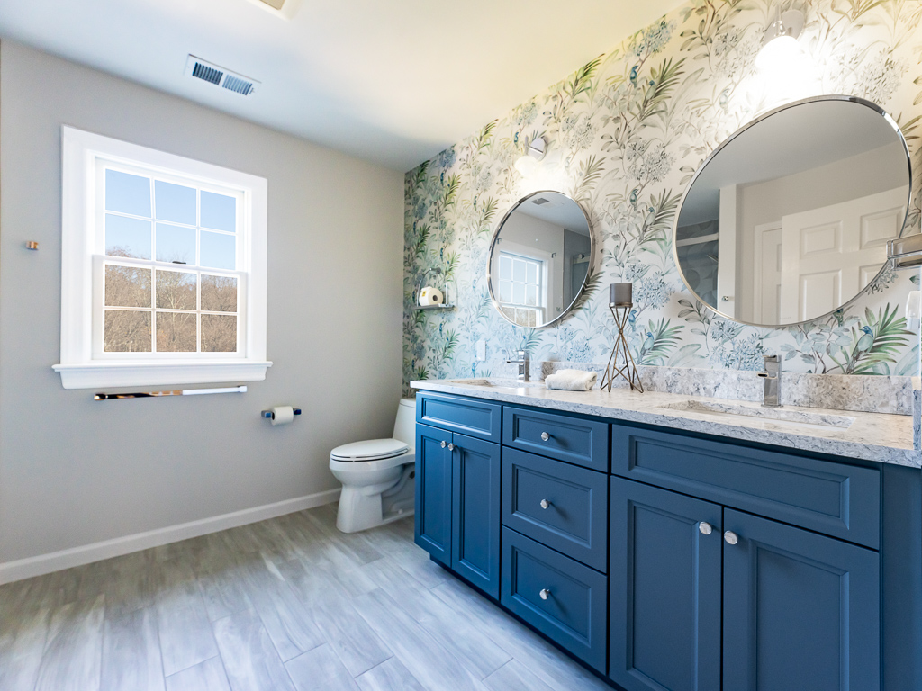 Modern Main Bath with Shower and window with blue cabinets bathroom remodel renovated by JMC Home Improvement Specialists