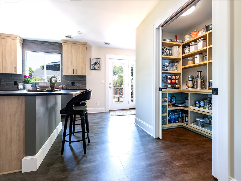 Kitchen remodel with large tile backspalsh, Vinyl flooring, black island,  flat panel cabinets, large walk-in pantry in Morris Plains, NJ remodeled by JMC Home Improvement Specialists