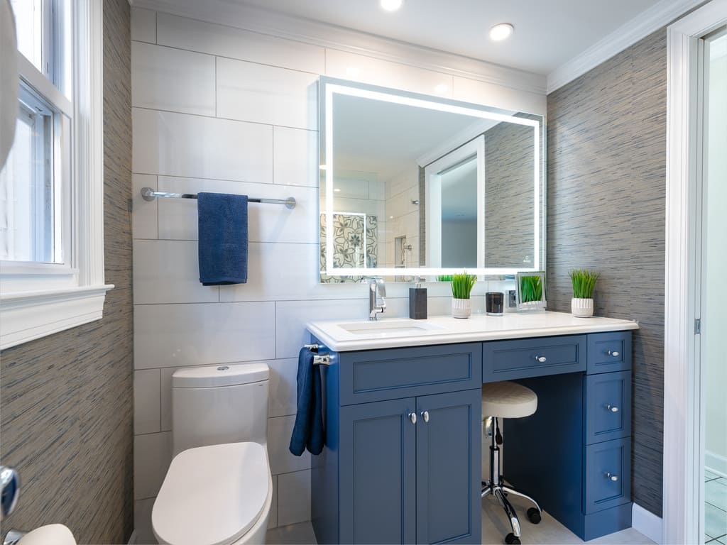 Large soaking tub with decorative grab bars and tile and glass panel shower door in Byram NJ remodeled by JMC