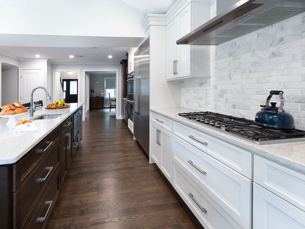 Two-tone kitchen remodel with cooktop, microwave drawer, double oven, kitchen island with prep sink in West Caldwell, NJ renovated by JMC Home Improvement Specialists