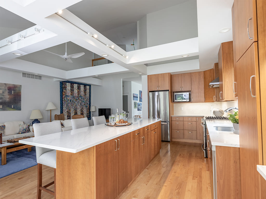 Open kitchen with glass cabinets, kitchen island, flat panel cabinets, open bookcase, custom ceiling beams in Somerset, NJ renovated by JMC Home Improvement Specialists